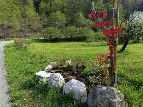 a garden with rocks and a sign on a road at Casa Castegner - Rooms in Seren del Grappa