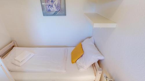 ペルツァーハケンにあるNeuKlosterhof App. 13の壁にベッドが備わる小さな客室です。