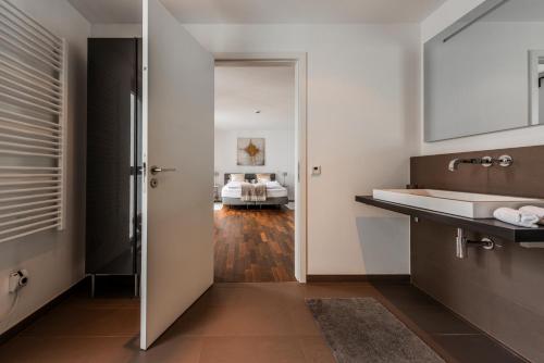 ケルンにあるExklusives Luxus Loft am Dom - Dachterrasse mit Traum-Aussichtのバスルーム(シンク付)、ベッドルーム1室が備わります。