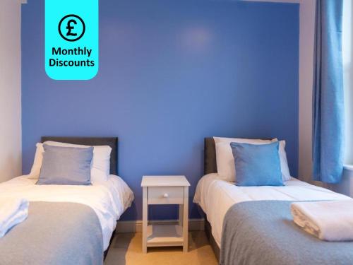 2 camas en una habitación con una pared azul en Large Apartment 2 Bedrooms - 2 Bathrooms, en Ipswich