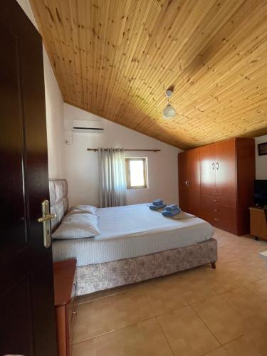 a bedroom with a large bed with a wooden ceiling at Vila Melisa Ksamil in Ksamil