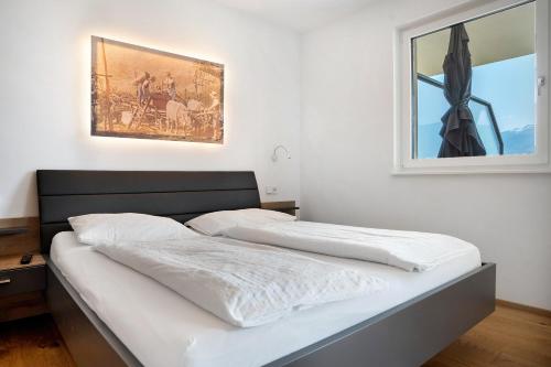 two beds in a bedroom with a picture on the wall at Bacchushof Apartment Merlot in Termeno