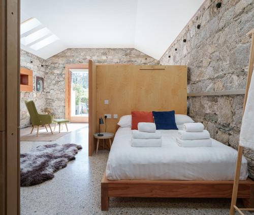 a bedroom with a bed and a stone wall at June Blake's Garden in Blessington