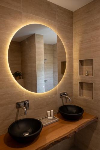 a bathroom with two sinks and a circular mirror at Nos Casita - 5 min walk to the beach in Pos Chiquito