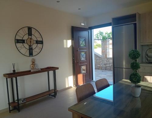 a dining room with a table and a clock on the wall at Villa Sunset in Samos