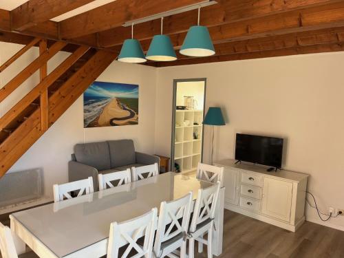 comedor y sala de estar con mesa y sillas en Patrimoine et immobilier Villas du Lac en Soustons