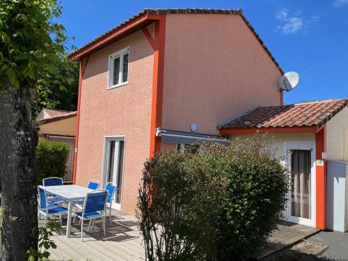 une maison avec une table et des chaises devant elle dans l'établissement Patrimoine et immobilier Villas du Lac, à Soustons