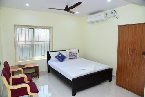 a small bedroom with a bed and a chair at ARUNA GRAND in Visakhapatnam