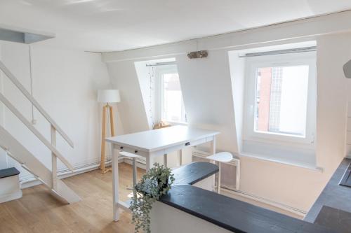 Habitación blanca con mesa y ventana en Lille Moulin, duplex lumineux 4P en Lille