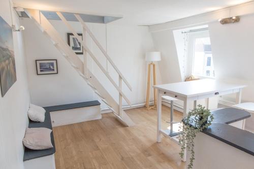 sala de estar con escalera, mesa y escritorio en Lille Moulin, duplex lumineux 4P en Lille