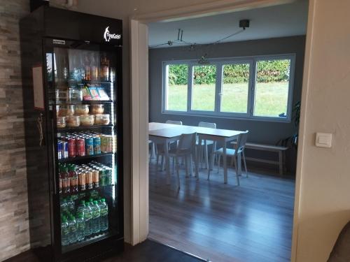 a dining room with a table and a soda refrigerator at Fasthôtel Clermont-Ferrand Gerzat in Gerzat