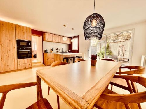 a kitchen and dining room with a wooden table and chairs at Sublime maison de Ville pour 6Pers, 2 chambres, au calme absolu in Marseille