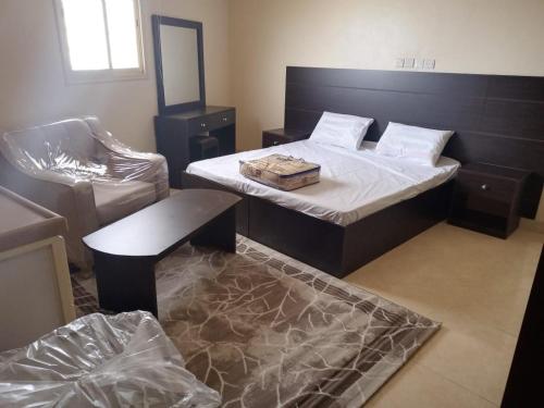 a bedroom with a bed and a table and a chair at شقق العاصفه4 in Khamis Mushayt