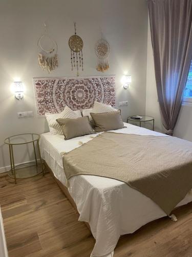 a bedroom with a large bed and two tables at La Sonrisa de Niki in Torrejón de Velasco