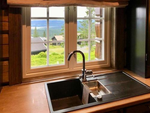 a kitchen sink and a window with a view at Newer lovely cabin in Birkebeinerbakken Sjusjøen in Ringsaker