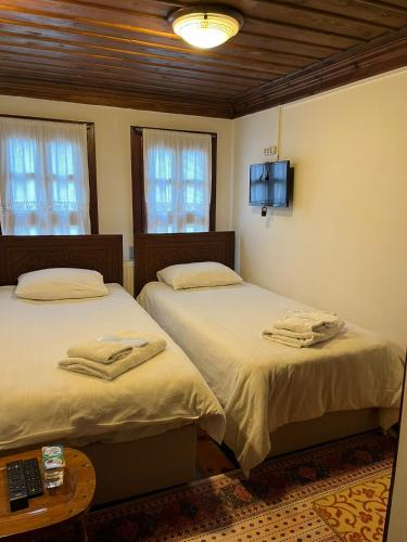 a bedroom with two beds and a tv on the wall at SEMRA HANIM KONAĞI in Safranbolu