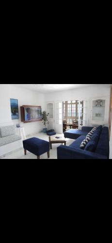 a living room with two blue couches and a couch at Un logement unique en bord de mer à Carthage in Carthage