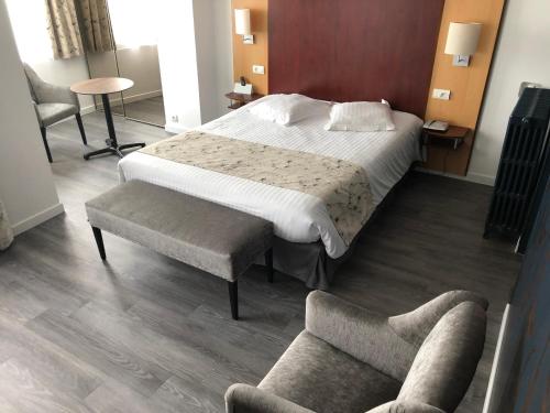 a bedroom with a large bed and a couch at Hôtel Windsor Contact Hôtel in Dieppe