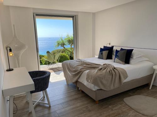 une chambre avec un lit et une vue sur l'océan dans l'établissement Luxury Villa Agnese l Sea view & infinity pool, à Porto-Vecchio