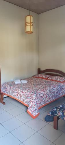 a bed in a room with a bedspread on it at Sítio Guaramiranga para 10 pessoas com fácil acesso in Guaramiranga