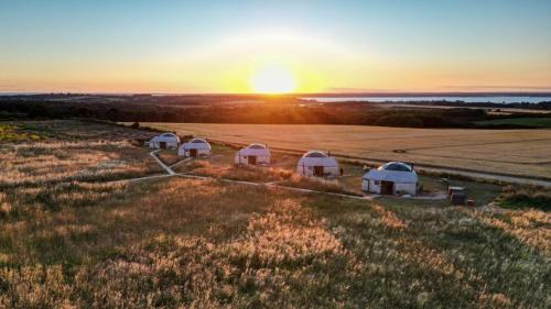 een groep tenten in een veld bij zonsondergang bij Dome Meadows 2 At Tapnell Farm in Yarmouth
