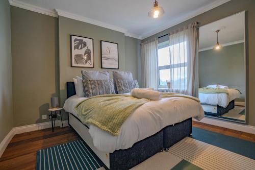 a bedroom with a large bed and a window at Cheeky and Beautiful Apartment in Greenwich in London