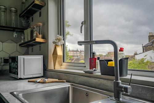 a kitchen counter with a sink and a window at Cheeky and Beautiful Apartment in Greenwich in London