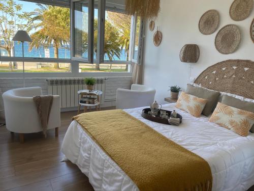 a bedroom with a large bed and a large window at Apartamento Comillas Beach in Comillas