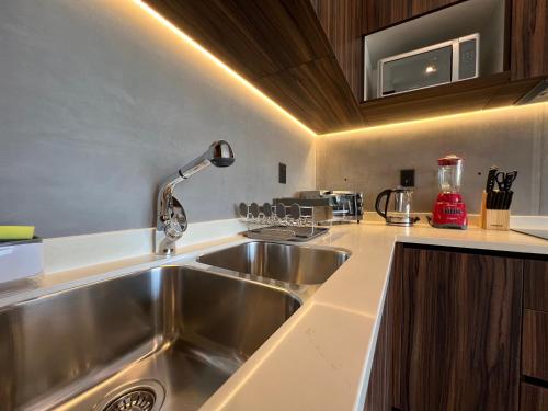 a kitchen with a sink and a counter top at Unwind | Private Balcony & Rooftop Pools | Casago in Tulum