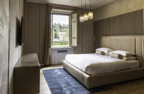 a bedroom with a large bed and a window at LE RÊVE DE NAIM in Florence