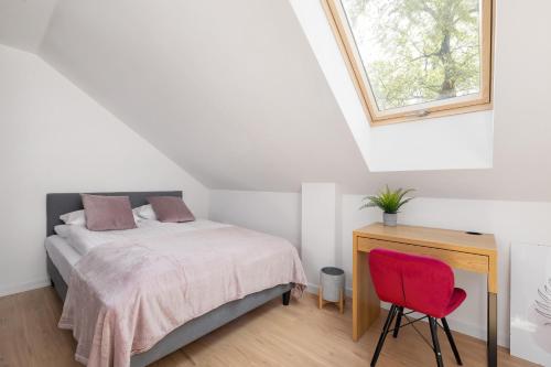 - une chambre avec un lit et une chaise rouge dans l'établissement Komfortowe Studio z Klimatyzacja dla 2 osob w Gliwicach, à Gliwice