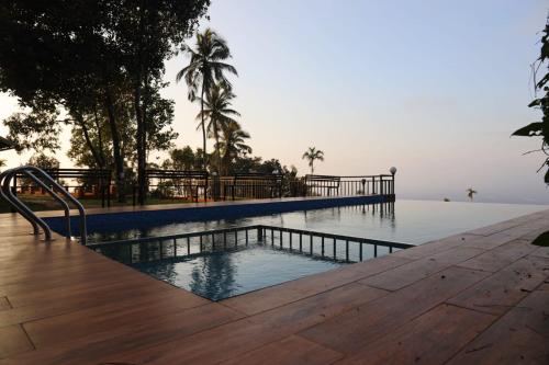 a swimming pool with a view of the water at Mistil Garden Resort in Kozhikode