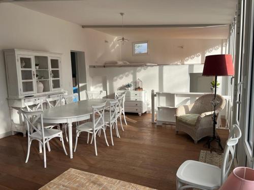 une cuisine et une salle à manger avec une table et des chaises dans l'établissement Villa familiale - Baie du Mont Saint-Michel, à Jullouville