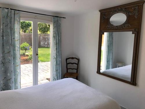 - une chambre avec un miroir, un lit et une chaise dans l'établissement Villa familiale - Baie du Mont Saint-Michel, à Jullouville