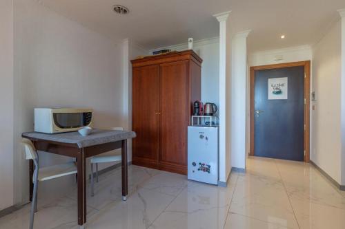 uma cozinha com uma mesa, um micro-ondas e um frigorífico em Gestione immobiliare Laura’s rooms em Roma