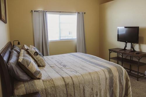 a bedroom with a bed with a television and a window at Chic Residence Near DT Sheridan in Sheridan
