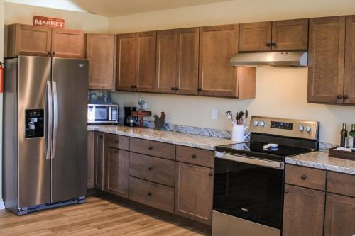 a kitchen with wooden cabinets and stainless steel appliances at Chic Residence Near DT Sheridan in Sheridan