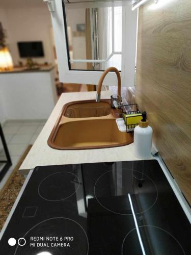 a kitchen counter with a sink and a mirror at Chrysanty's tea house in Kalabaka