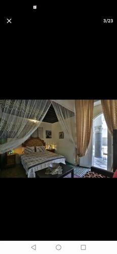 - une chambre avec 2 lits et une fenêtre avec des rideaux dans l'établissement One bedroom apartement with enclosed garden and wifi at Fes El Bali Fes, à Fès