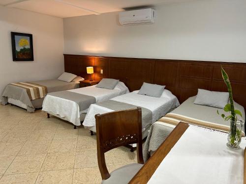 a hotel room with two beds and a table at Terrazas Vista Verde in Asuncion
