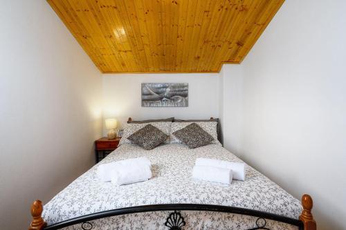 a bedroom with a bed with a wooden ceiling at Charmantes Apartment im Grünen mit Pool in Labin