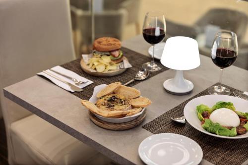 a table with two plates of food and wine glasses at Hotel Best 4 Barcelona in Barcelona