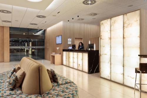 a woman standing at a counter in a lobby at Hotel Best 4 Barcelona in Barcelona