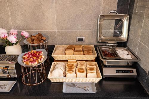 a counter with trays of food and plates of pastries at Holiday Inn Express - Temuco by IHG in Temuco