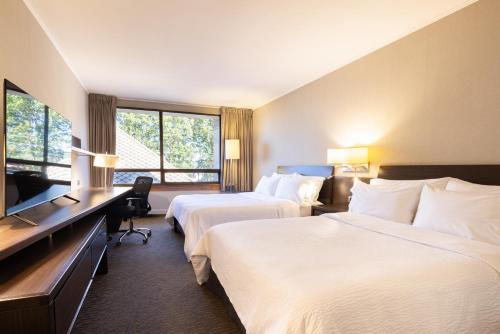 a hotel room with two beds and a television at Holiday Inn Express - Temuco by IHG in Temuco