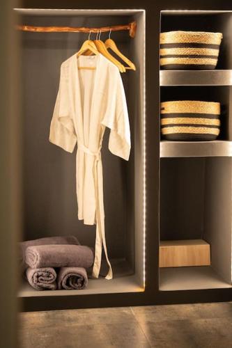 a closet with a white robe and towels at Cooper's Cave house with heated Jacuzzi in Megalokhori