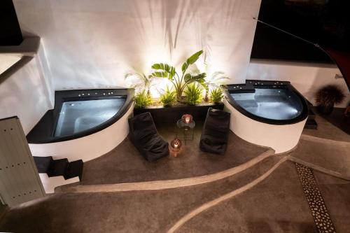 an overhead view of two hot tubs in a room with plants at Cooper's Cave house with heated Jacuzzi in Megalokhori