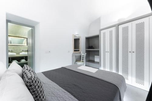 a white bedroom with a bed and a closet at Cooper's Cave house with heated Jacuzzi in Megalokhori