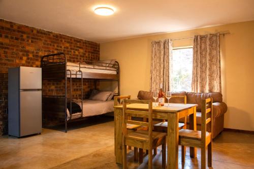 a dining room with a table and a bunk bed at Melamar Estate in Marloth Park
