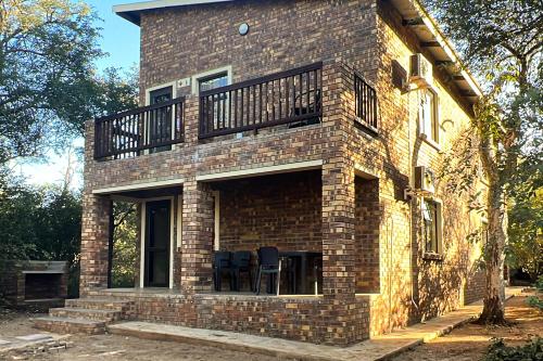 a brick building with a balcony on top of it at Melamar Estate in Marloth Park